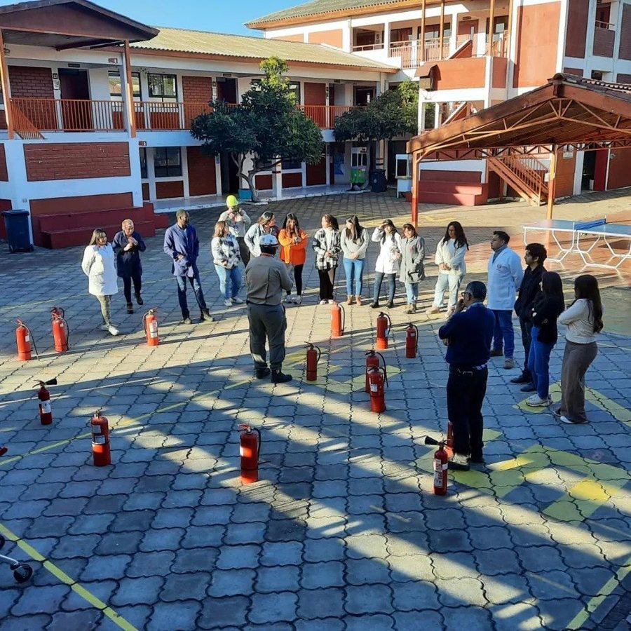 Capacitación de uso de extintores en el patio de un colegio