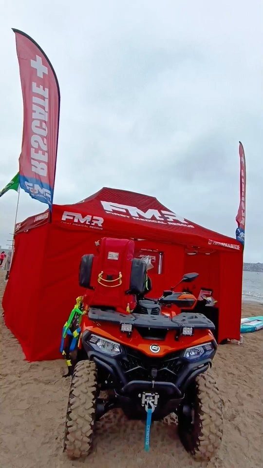 Puesto médico de First Medical Rescue con carpa y cuatrimoto de rescate en la playa