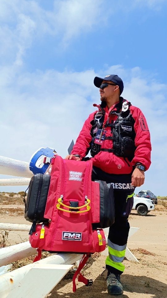 Paramédico con mochila médica en la playa