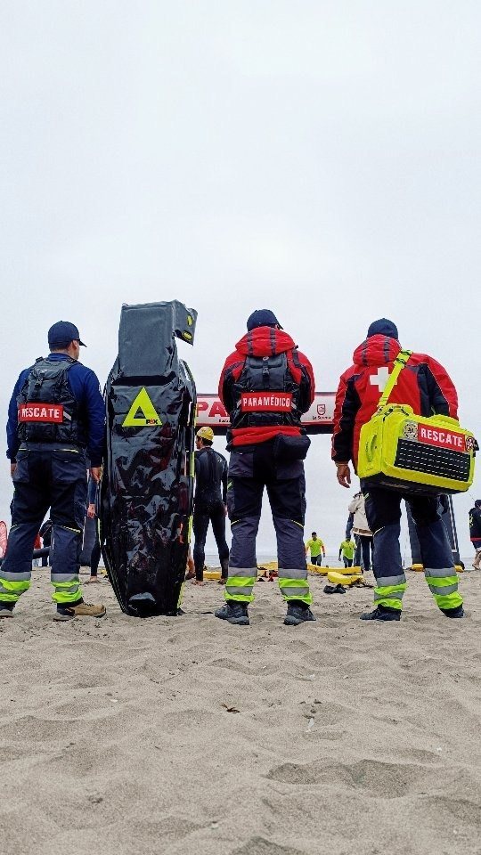 Equipo de rescate con tablas espinales en la playa